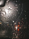 Rain drops on window with road light bokeh, water drop on the glass, night storm raining car driving concept. Night car Royalty Free Stock Photo