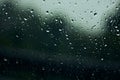 Rain drops on window, with trees and leaves outside Royalty Free Stock Photo