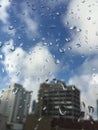 Rain drops on windowpane against buildings