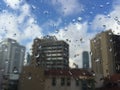 Rain drops on windowpane against buildings