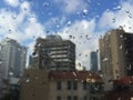 Rain drops on windowpane against buildings