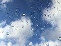 Rain drops on windowpane against clouds