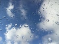 Rain drops on windowpane against clouds