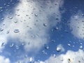 Rain drops on windowpane against clouds