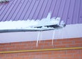 Rain Gutter damaged by ice and snow. Broken roof gutter pipeline by icicles