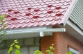 Rain gutter downspout drain pipe installation with metal roof snow board protection Royalty Free Stock Photo