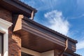 Rain gutter on a modern brick house with plastic windows.