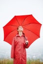 Rain, happy and red umbrella with woman in nature for winter, storm and carefree. Happiness, weather and cold with Royalty Free Stock Photo