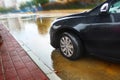 Rain in Israel, car driving through a puddle, creating waves and splashes on the rain water. The main meaning of the photo: floods Royalty Free Stock Photo