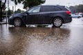 Rain in Israel, flooding, puddles. Car floods with rainwater in a parking lot, circles on the water, raindrops. Rainy Winter Royalty Free Stock Photo