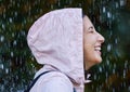 The rain makes me feel alive. an attractive young woman standing alone outside in the rain.