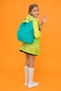 Rain is not hindrance. Schoolgirl raincoat going to school waving hand. Waterproof fabric for your comfort. Rainproof Royalty Free Stock Photo