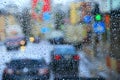 Rain outside window on background of city lights. Drops of water dropping on glass during rain. Droplets of water beyond window Royalty Free Stock Photo