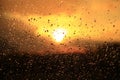 Rain outside window on sunset background. Water drops on glass during raining