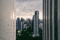 Rain over Bangkok: Out of focus cityscape behind the window glass with rain drops Royalty Free Stock Photo