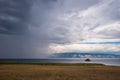 Rain over Lake Baikal and the cows on the shore on a cloudy day. Royalty Free Stock Photo