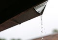 Rain pouring off roof against nature background Royalty Free Stock Photo