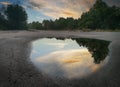 After rain puddle by the road with sky reflection on the surface Royalty Free Stock Photo