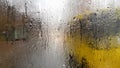 Rain on the rear window of a car in autumn. Inside view of the road with moving cars in the city through the window from the car