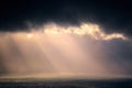 Rain on the sea with stormy clouds and sun rays Royalty Free Stock Photo