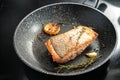 Rain trout fillet with a crispy fried skin, garlic, lemon and herbs in a frying pan, healthy cooking with fish, copy space, Royalty Free Stock Photo