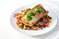 Rain trout fillet with a crispy fried skin on vegetables from the oven and parsley garnish served on a white plate, healthy fish Royalty Free Stock Photo