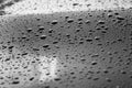 Rain or water drops different size on a black shiny car hood surface. Water droplets on dark iron surface and texture Royalty Free Stock Photo