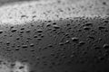 Rain or water drops different size on a black shiny car hood surface. Water droplets on dark iron surface and texture Royalty Free Stock Photo