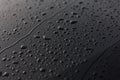 Rain or water drops different size on a black shiny car hood surface. Water droplets on dark iron surface and texture Royalty Free Stock Photo