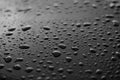 Rain or water drops different size on a black shiny car hood surface. Water droplets on dark iron surface and texture Royalty Free Stock Photo