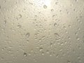 Rain water Drops on glass window on a cloudy day morning with sun in background hide and seek behind clouds Royalty Free Stock Photo