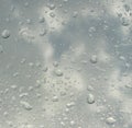 Rain water Drops on glass window on a cloudy day morning with sun in background hide and seek behind clouds Royalty Free Stock Photo