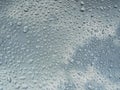 Rain water Drops on glass window on a cloudy day morning with sun in background hide and seek behind clouds Royalty Free Stock Photo