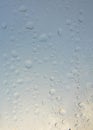 Rain water Drops on glass window on a cloudy day morning with sun glow glare in background hide and seek behind clouds Royalty Free Stock Photo