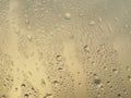 Rain water Drops on glass window on a cloudy day morning with sun glow glare in background hide and seek behind clouds Royalty Free Stock Photo