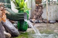 Rain water is pouring from the green draining gutter on the mossy ground Royalty Free Stock Photo