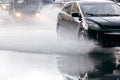 Rain water splashing from car wheels on flooded road Royalty Free Stock Photo