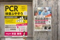 Rain wet poster denouncing low rate of PCR tests performed by government of Japan