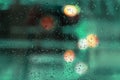 Rain on the window and bokeh city lights. Illuminated neon lights, wet glass with raindrops. Abstract bright blurred Royalty Free Stock Photo