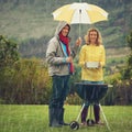 The rain wont stop our barbecue. a couple happily barbecuing in the rain.