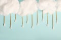 Rain from wooden ear sticks.Natural Cotton Buds For Eye Cleaning.Blue backdrop.Cotton clouds Royalty Free Stock Photo