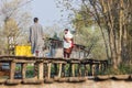 People on a raised walkway on the shores of Dal Lake