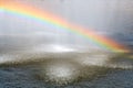 Rainbow above water surface. Rainbow from city fountain splash water drops