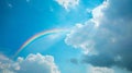 Rainbow appearing in the midst of clouds against a blue sky after light rain Royalty Free Stock Photo