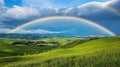 Rainbow arching over lush green hills and valleys Royalty Free Stock Photo
