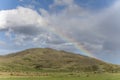 Rainbow on barren slopes near Omarama, New Zealand