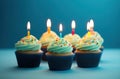 rainbow birthday cupcakes on blue background Royalty Free Stock Photo