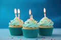 rainbow birthday cupcakes on blue background Royalty Free Stock Photo