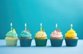 rainbow birthday cupcakes on blue background Royalty Free Stock Photo