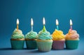 rainbow birthday cupcakes on blue background Royalty Free Stock Photo